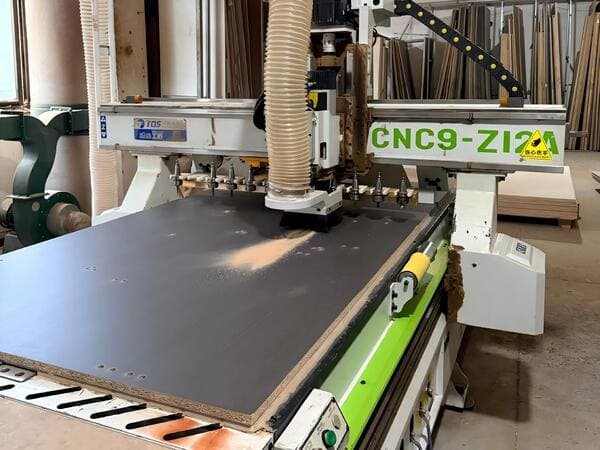 Melamine-faced board being processed on a CNC machine for custom cabinet parts